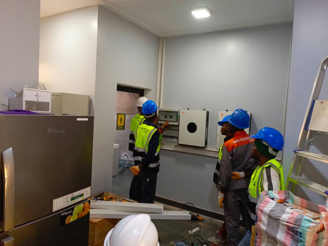 Enabel, Lubumbashi — Intervenants devant les équipements muraux et un coffret électrique