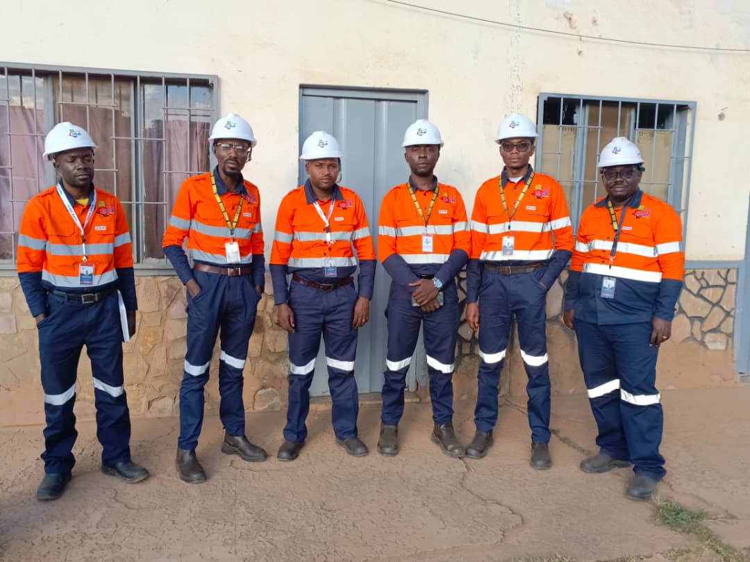 Équipe en tenue de travail et casques devant un bâtiment